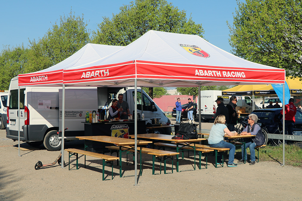 Two red and white street food tents offer space for several beer tent bench and table sets.