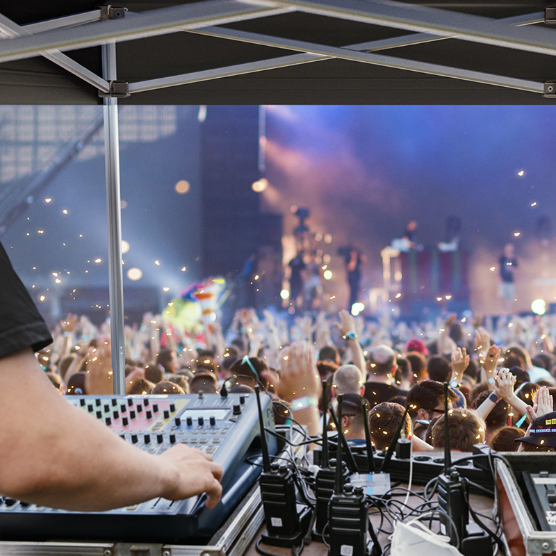 A FOH tent from Pro-Tent being used by a technician at an open-air concert.