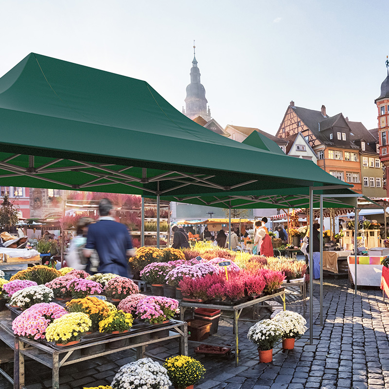 A market tent from Pro-Tent being used to sell flowers in a marketplace.
