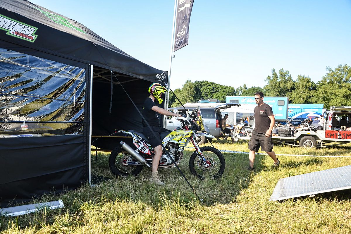 Une équipe de course utilise une tente de course Pro-Tent et ses accessoires comme tente d’équipe lors d’une course de moto.