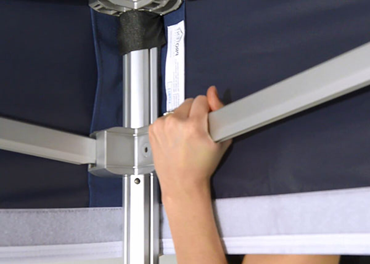 The easy-up tent frame is engaged during assembly.
