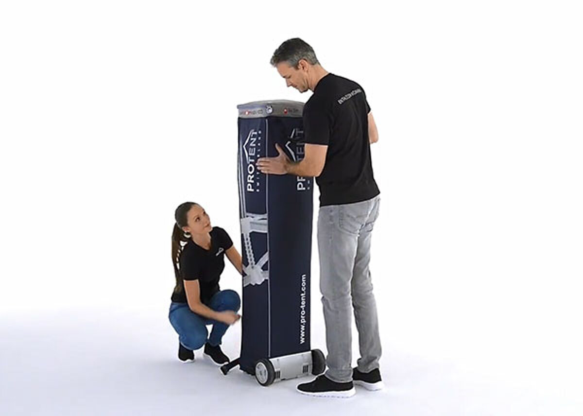 A man and a woman open the transport bag for the easy-up tent.