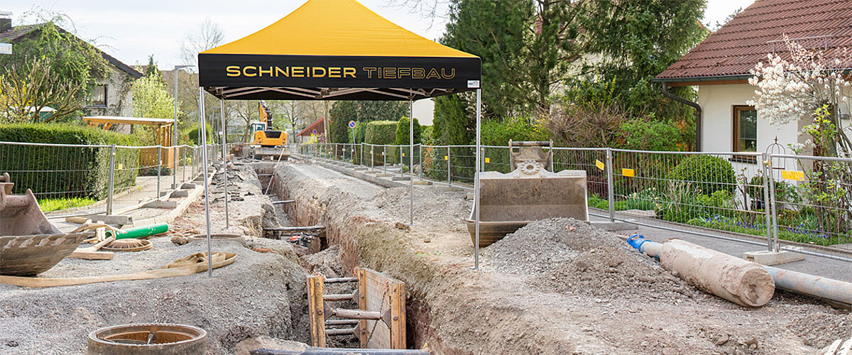 Arbeits- und Bauzelte spenden Schatten auf Baustellen. Ein Arbeitszelt der Firma Schneider Tiefbau schattiert Kanalarbeiten.