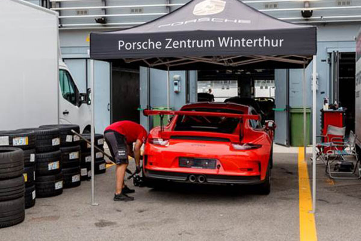 Un Porsche este reparat sub un cort pliabil