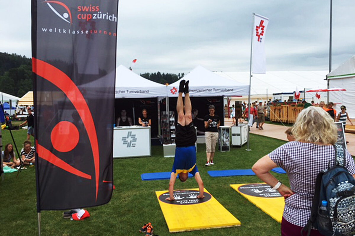 Un homme fait le poirier lors du #SwissCupChallenge.