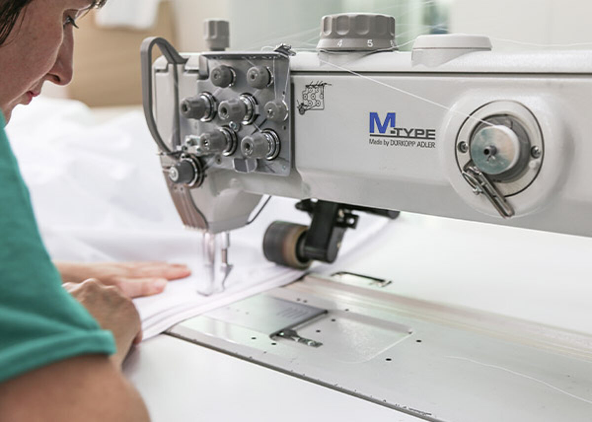 Une couturière fabrique une tente pour artisans.