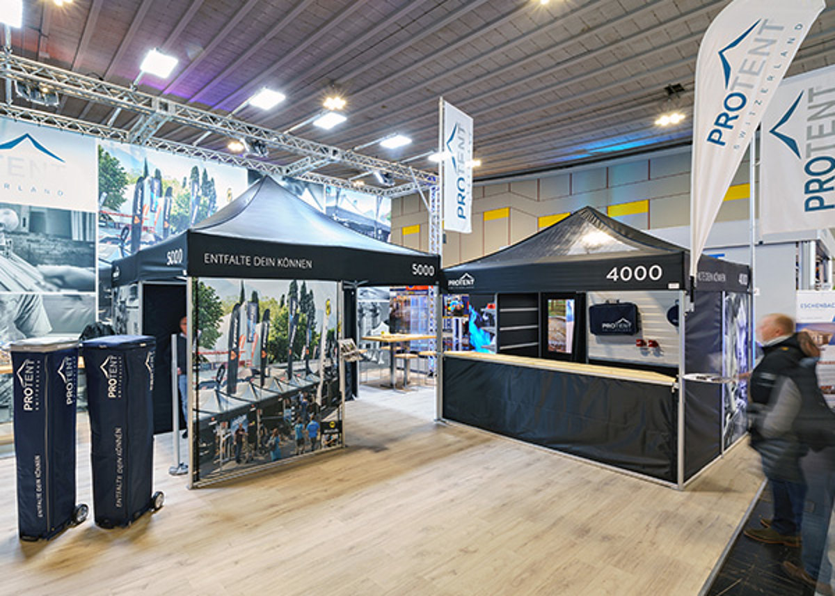 Two black Pro-Tent exhibition tents are connected to form one large stand.