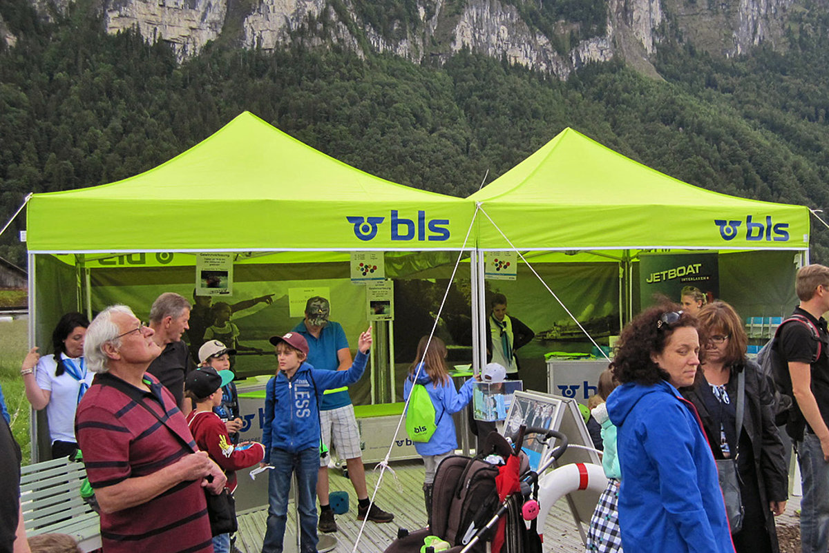 Une tente événementielle Pro-Tent est installée lors d'un événement très fréquenté dans un paysage de montagne.