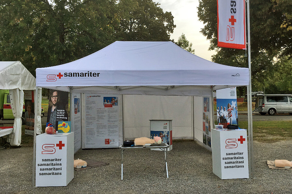 Ein Sanitätszelt der Samariter mit bedrucktem Dach und Fahne als Kennzeichnung.