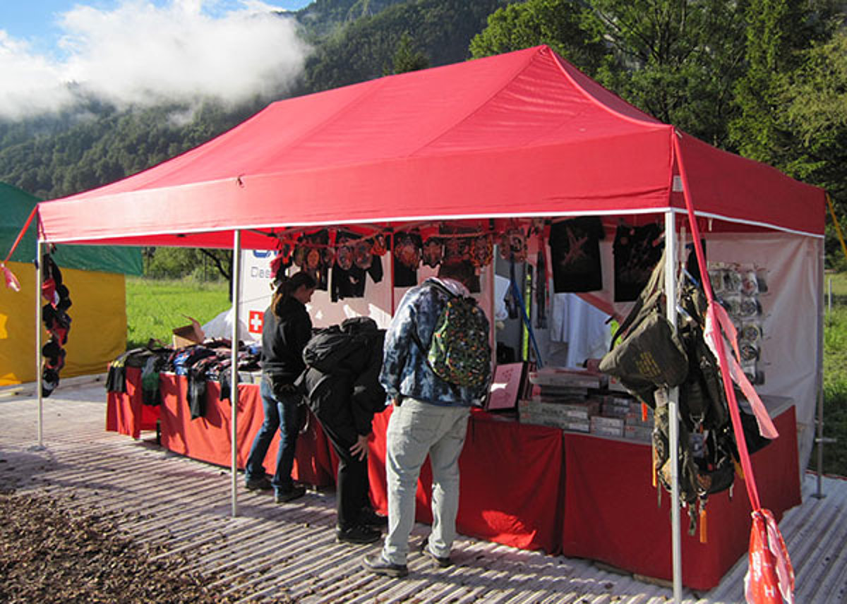 Une tente de marché rouge est utilisée comme stand de vente.