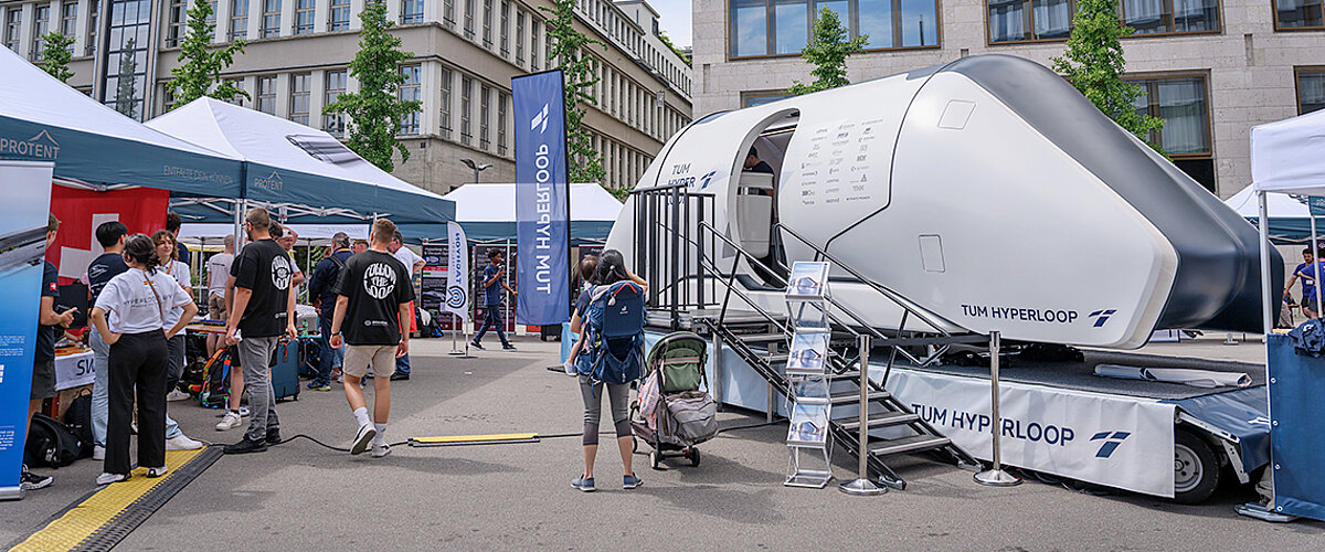 Pro-Tent is a Gold Partner of the European Hyperloop Week 2024 A Hyperloop pod stands next to an area full of Pro-Tent folding tents.