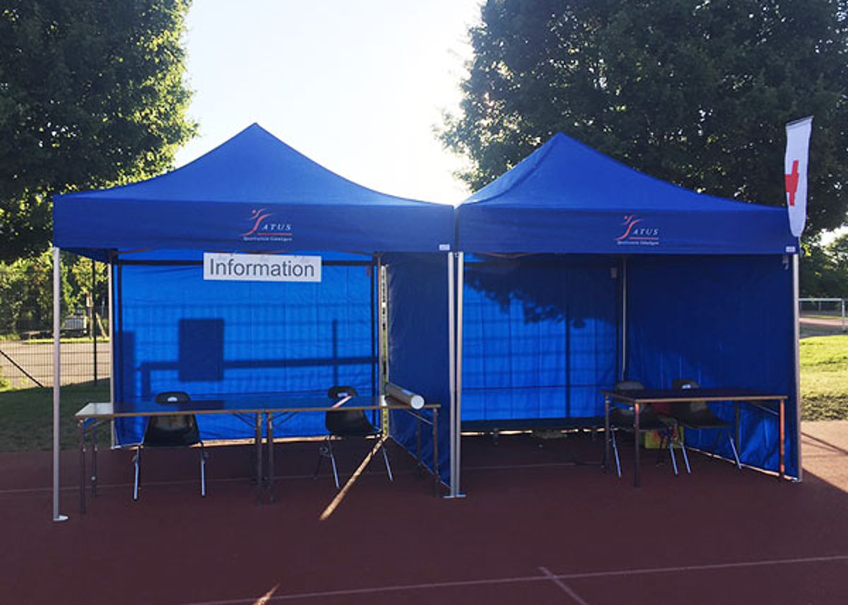A club tent serves as an info counter at a sports event.