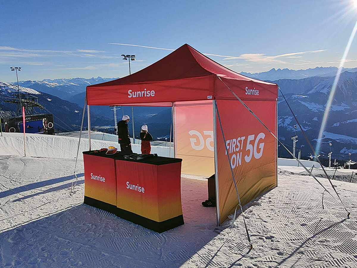 A Pro-Tent promotion tent being used by Sunrise as an advertising stand in a snowy ski resort.