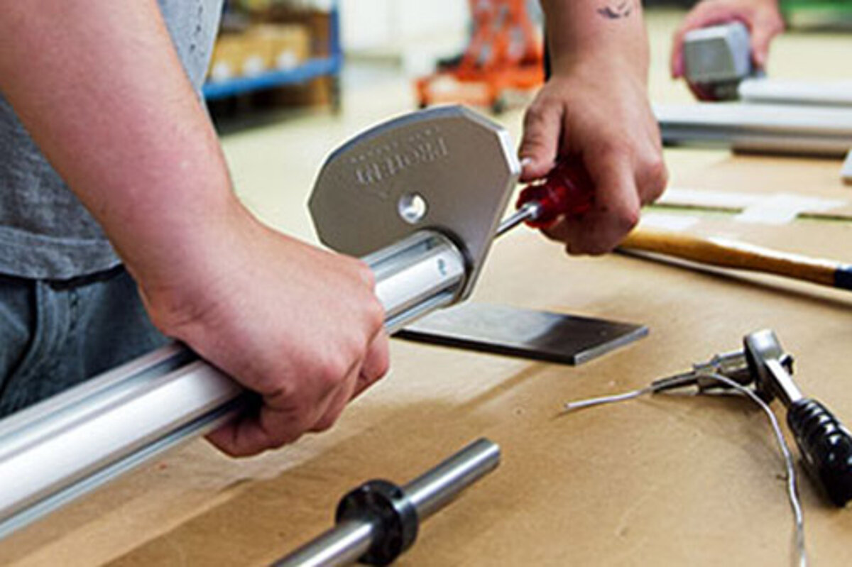 A Pro-Tent employee screws together a support leg.