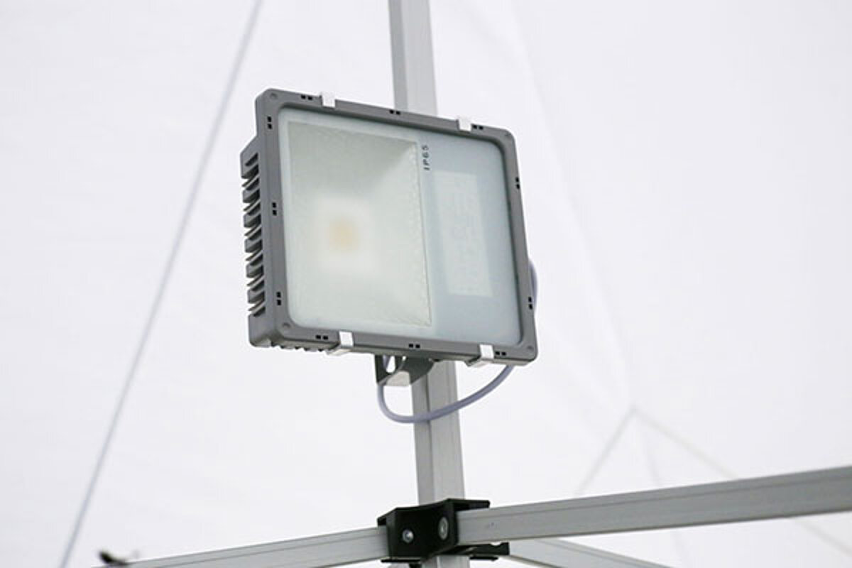 Ein Flutlichtstrahler ist im Faltzeltgestell befestigt.