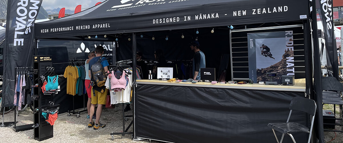 Un gazebo pieghevole in uso da un produttore di abiti a una fiera outdoor.