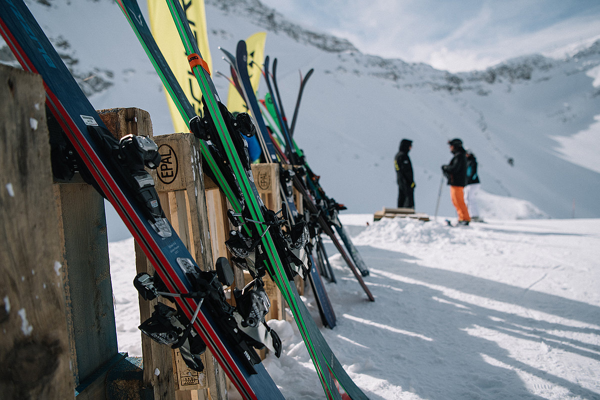 Mehrere Paar Ski sind an ein Holzgestell angelehnt.